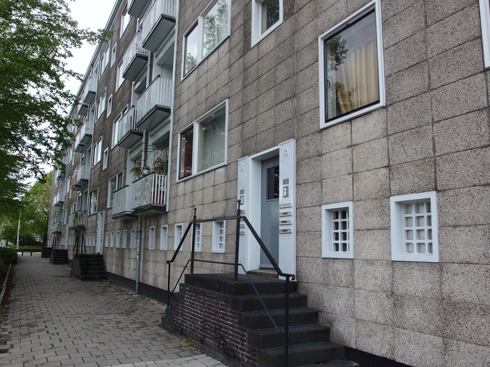 Een appartementengebouw met balkons en buitentrappen.