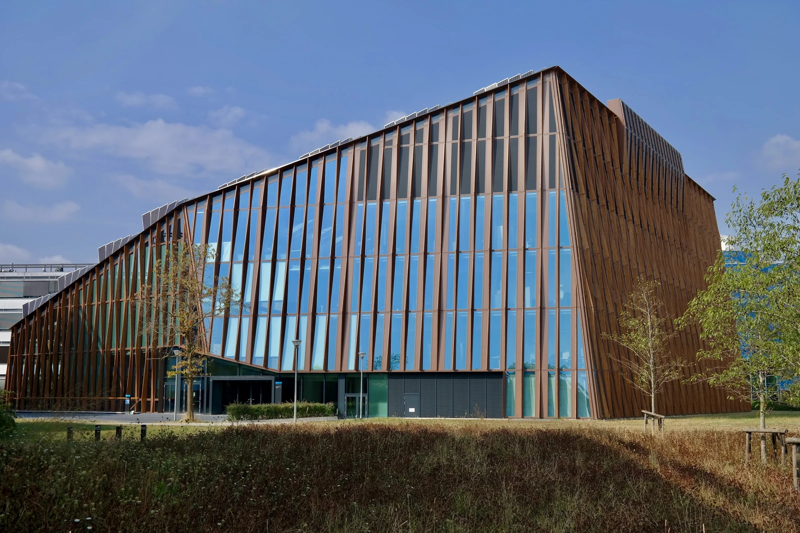 Een gebouw met glas en verticale houten gevelelementen.